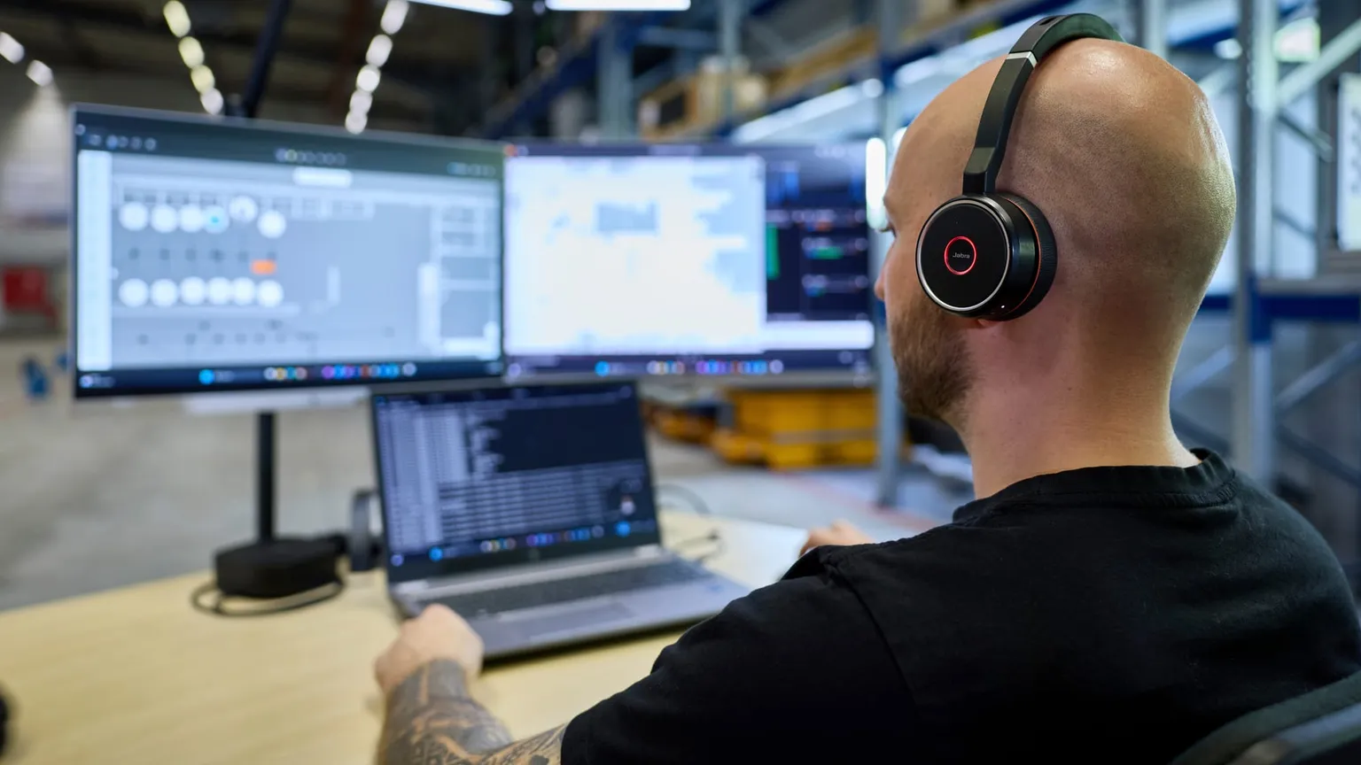 Remote-Arbeitsplatz, Mitarbeiter mit Headset vor der Flottenansicht
