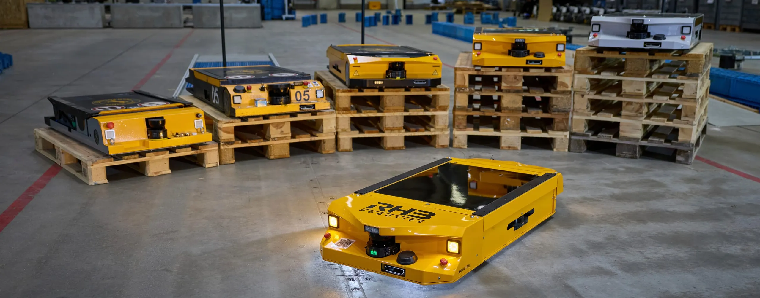 Sechs Fahrzeuggenerationen von RHB-Robotics nebeneinander aufgestellt, vorne die aktuelle Baureihe